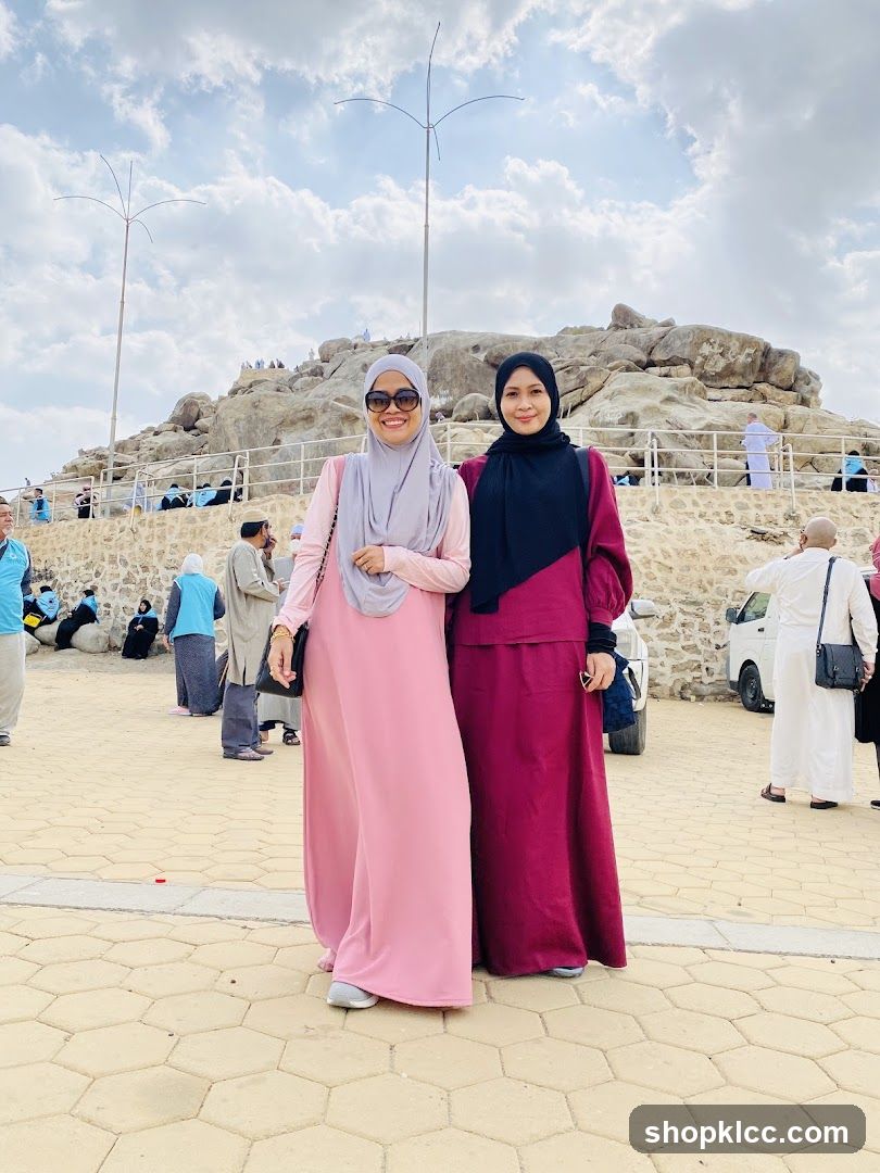 Two women posing in front of a rocky hill