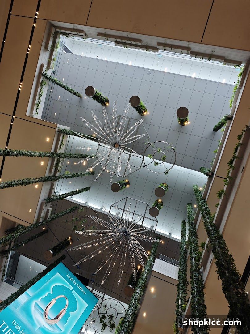 Interior of a modern shopping mall with decorative lighting and greenery.