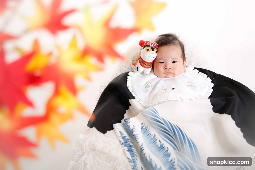 Baby with a toy cat and autumn leaves
