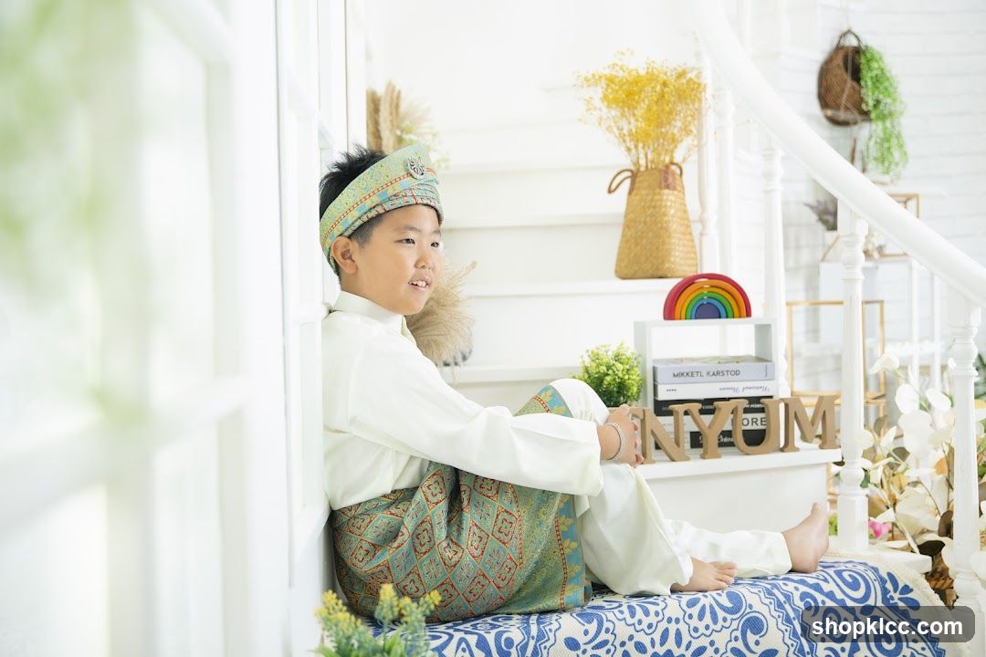 Boy in Traditional Attire Sitting on Stairs