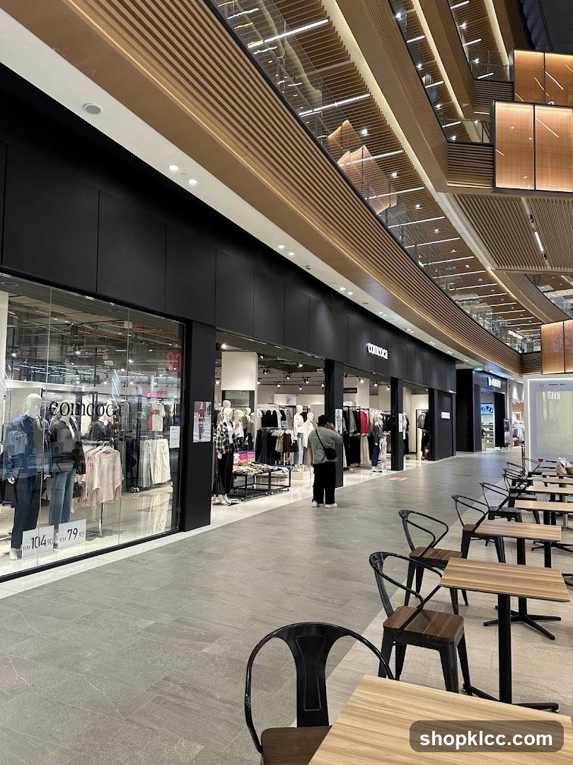 Modern Shopping Mall Interior with Clothing Stores and Seating Area