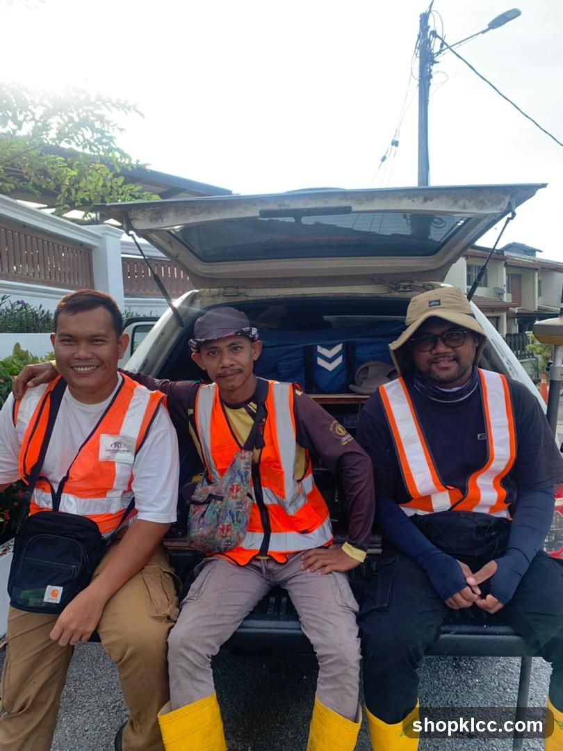 Three men in safety vests sitting in the back of a vehicle