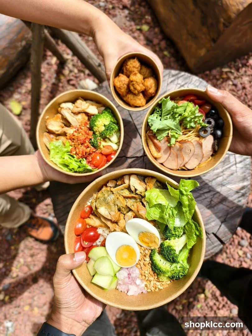 Group of people holding bowls of food outdoors