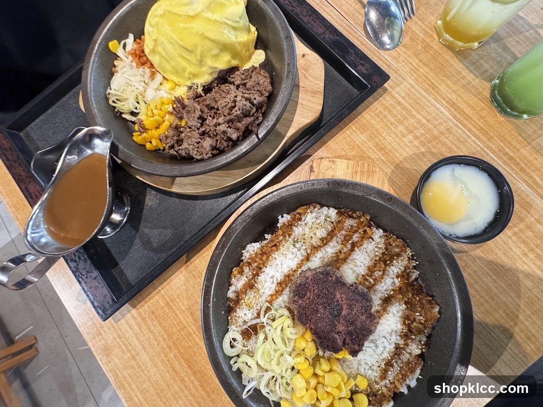 Two bowls of rice with toppings and a side of sauce