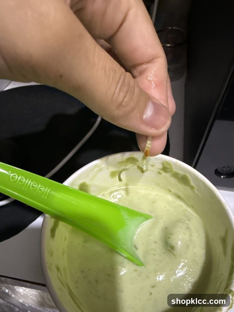 Hand holding food over a bowl