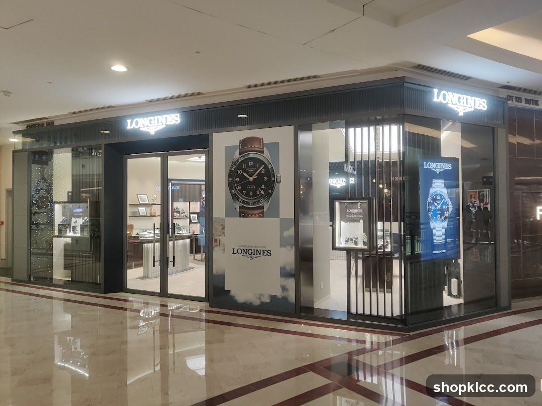 The exterior of a Longines watch store. The store has large glass windows and doors, with prominent "LONGINES" signage above the entrance. Large advertisements for Longines watches are displayed on the windows. Inside, display cases showcase watches.