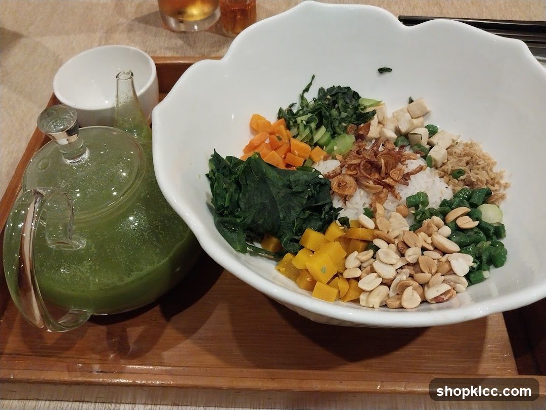 Rice bowl with assorted toppings and a teapot of green liquid