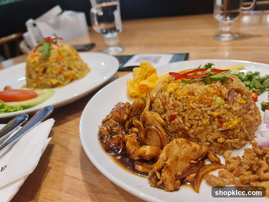 Two plates of fried rice with chicken