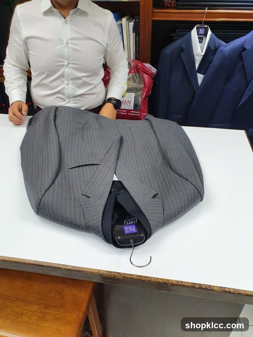 Tailor folding a pinstripe suit jacket