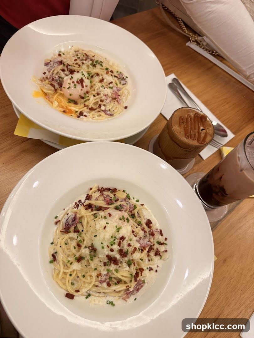 Two plates of pasta with drinks