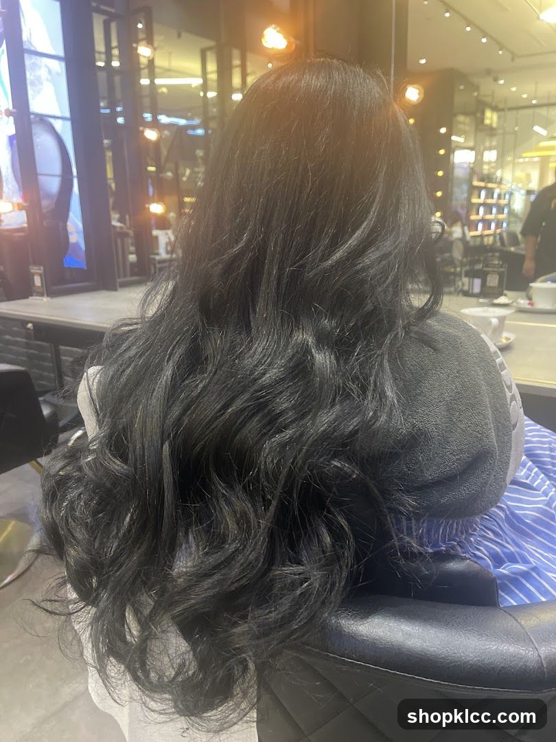 Woman with long, wavy black hair in a salon