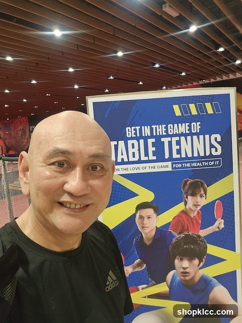 Man posing with table tennis advertisement