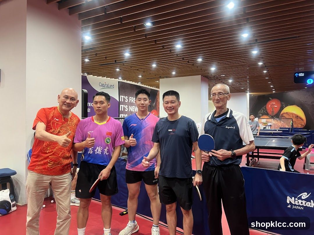 Group of men posing for a photo at a table tennis facility