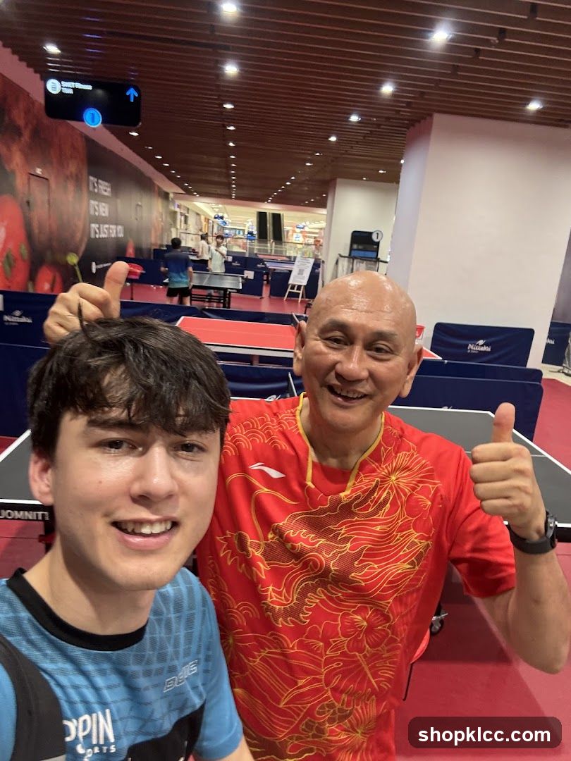 Two men giving thumbs up in a table tennis arena