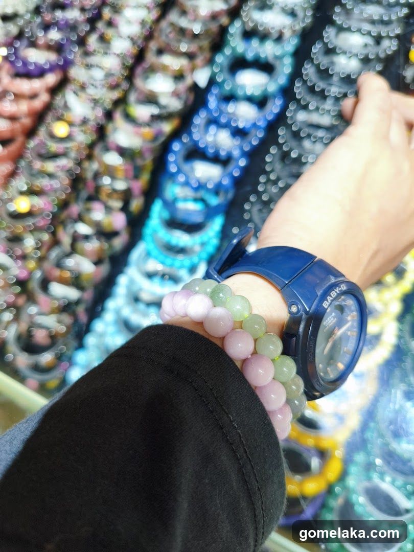 Hand wearing watch and bracelets in market setting