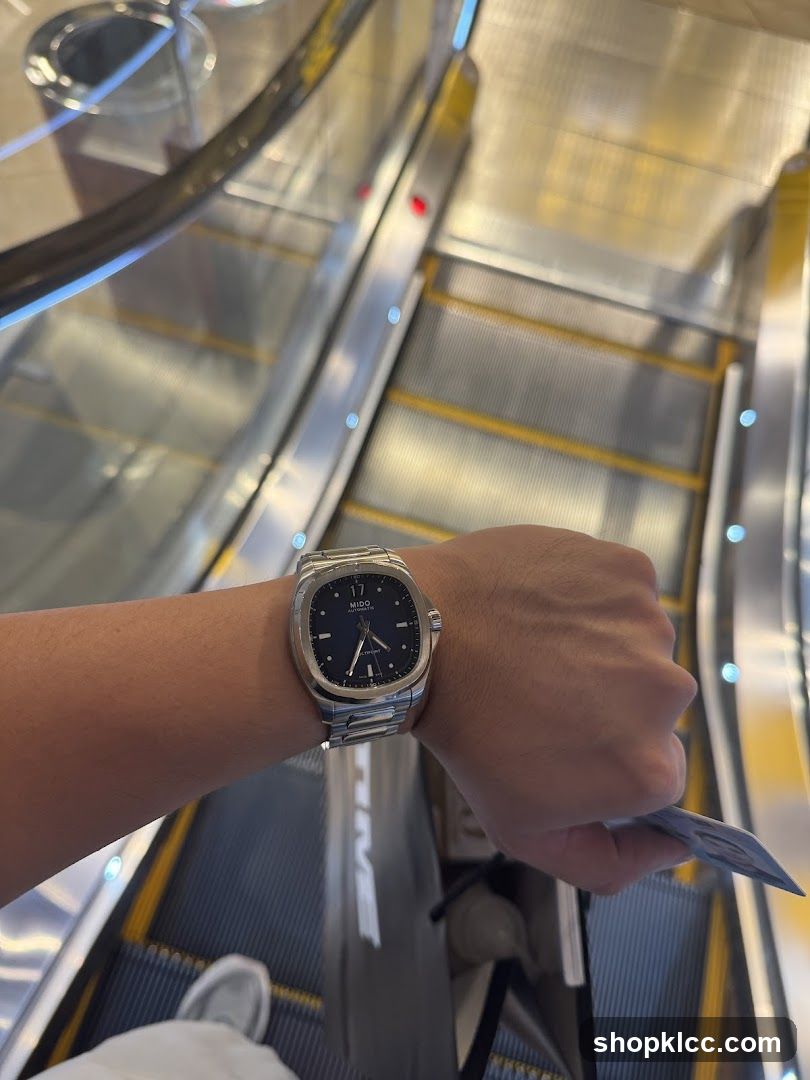 Person wearing a watch on an escalator