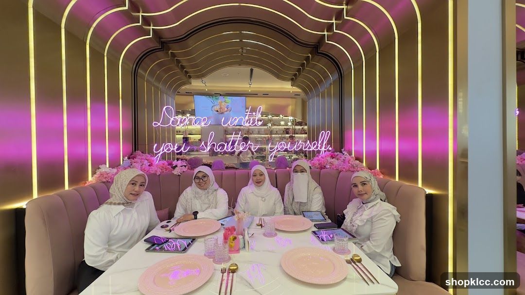 Women at a table in a pink-themed cafe