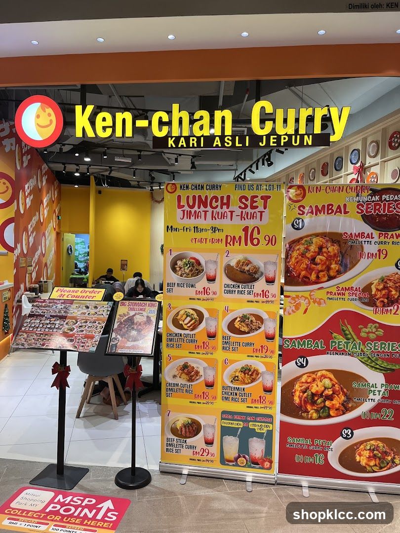 The exterior of a Ken-chan Curry restaurant with a prominent yellow sign and a menu displayed outside.
