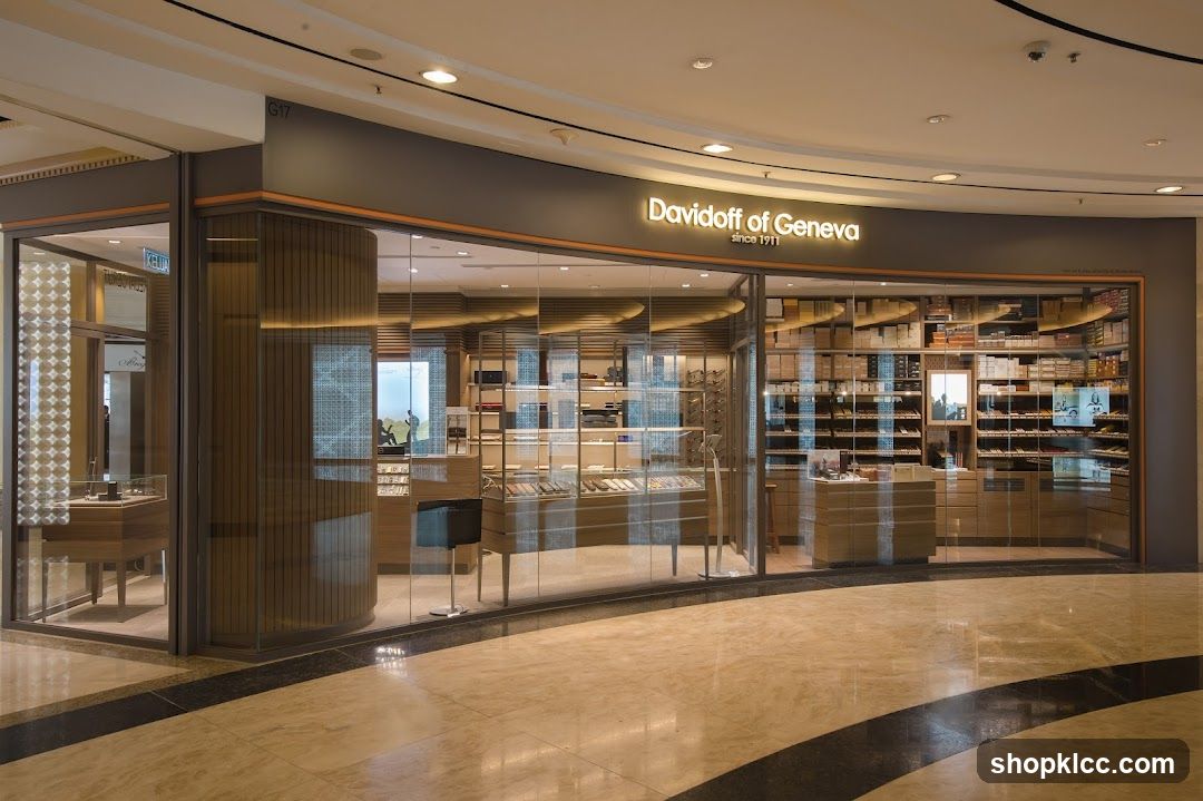 A well-lit, modern Davidoff of Geneva store with a large glass facade. The store displays a variety of products, including what appear to be cigars and accessories, arranged on shelves and in display cases. The interior is visible through the glass, showcasing a clean and organized layout. The store's name, "Davidoff of Geneva since 1911," is prominently displayed above the entrance.