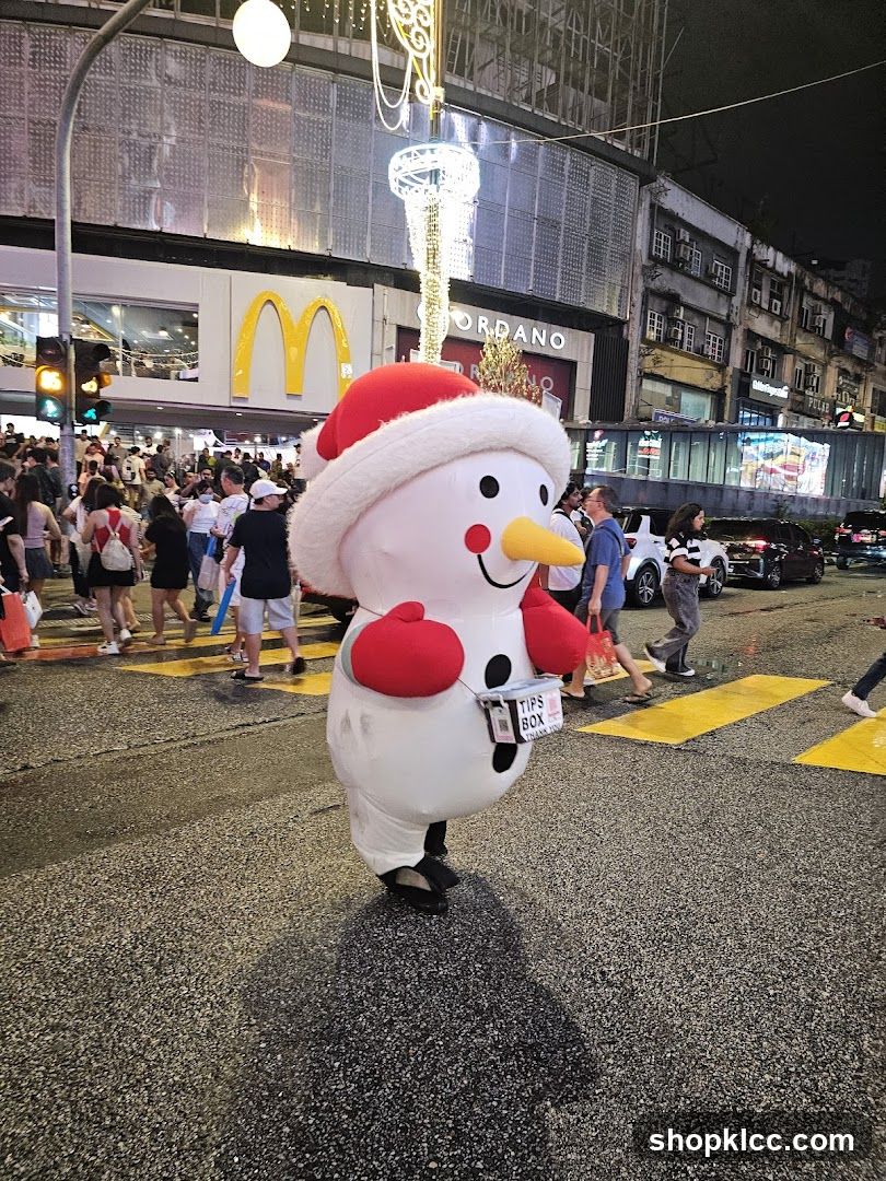 Snowman mascot with tips box on street at night