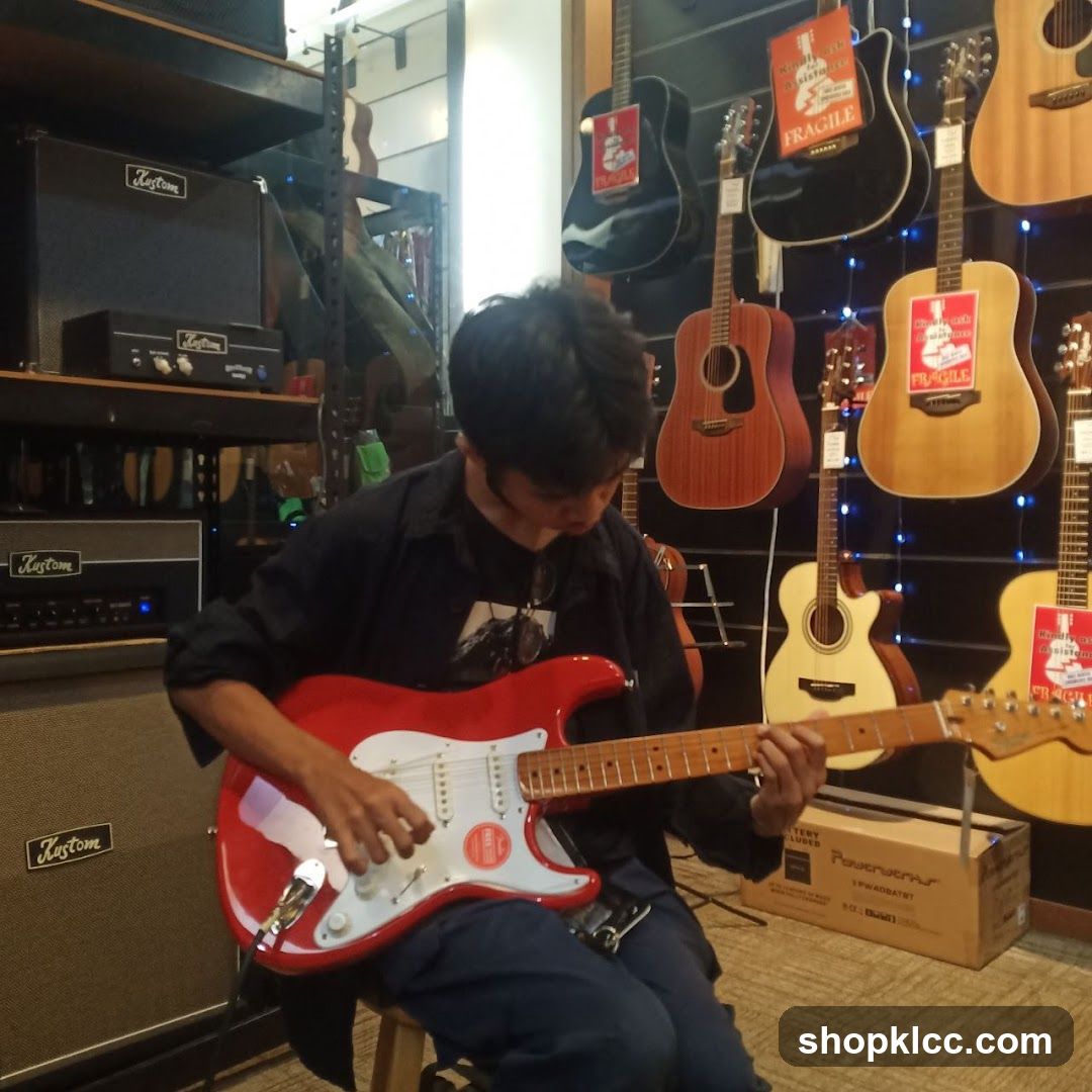 Man playing a red electric guitar in a music store