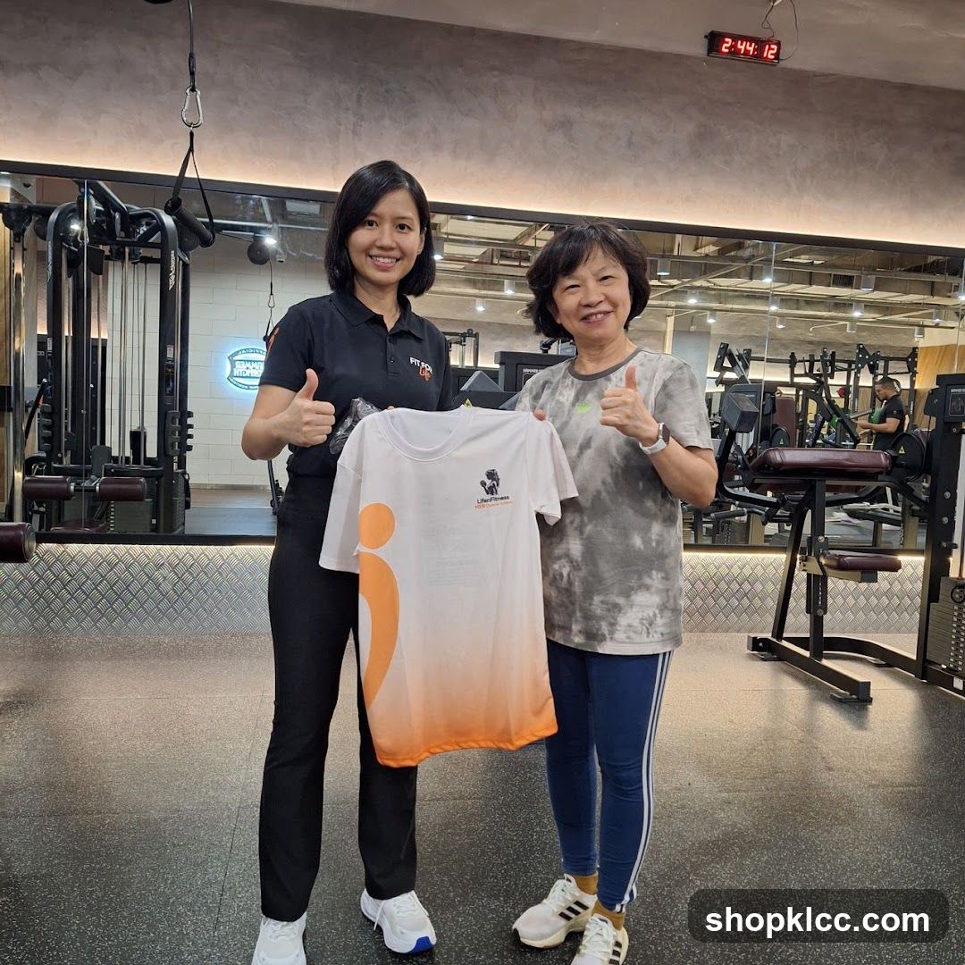 Two women holding a t-shirt in a gym