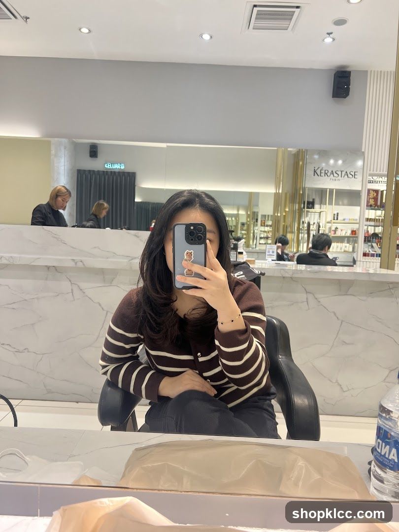 Woman taking a mirror selfie in a salon