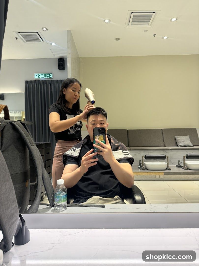 Hairdresser drying client's hair