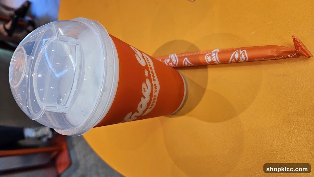 Orange cup and straw on table