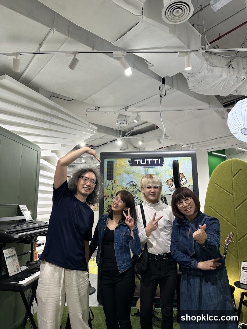 Four people posing in a music store