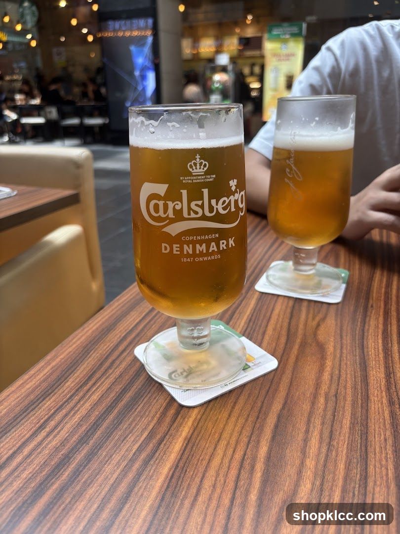 Two glasses of Carlsberg beer on a wooden table