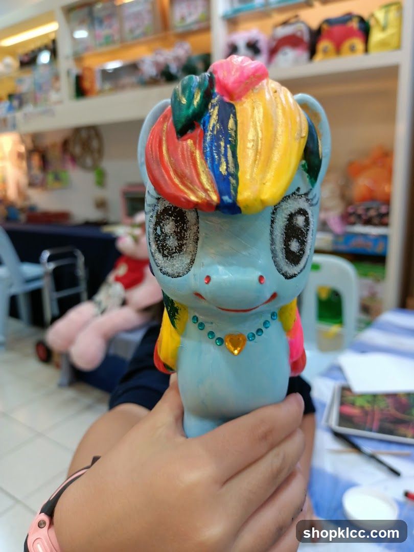 Hand holding a painted ceramic pony figurine