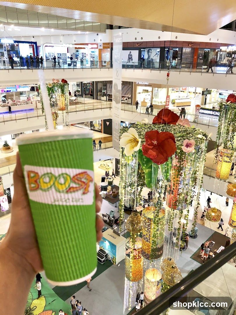 Hand holding a Boost Juice cup in a mall