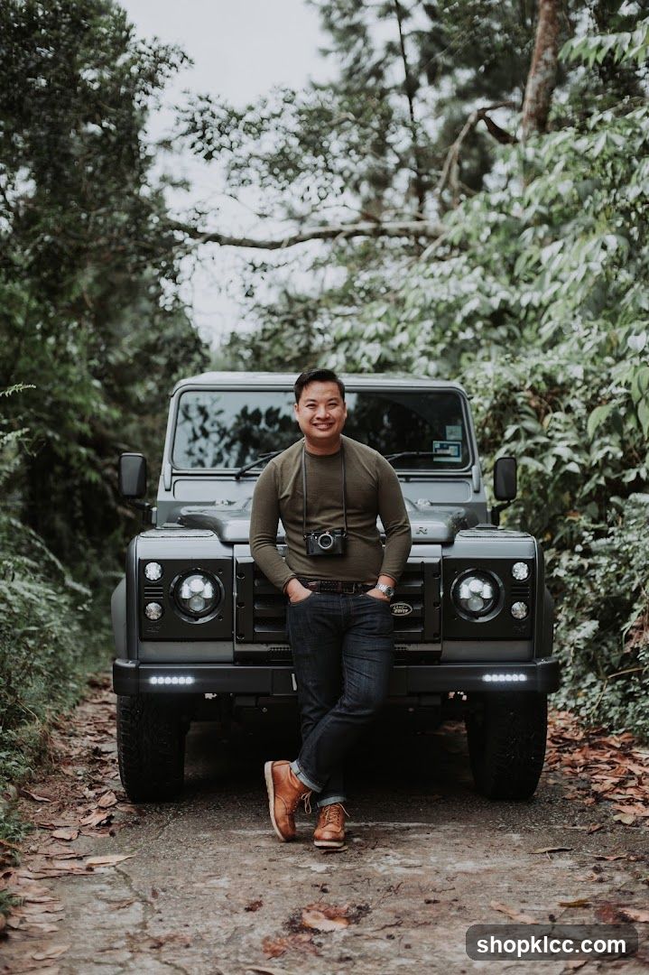 Man Posing with a Land Rover in a Forest