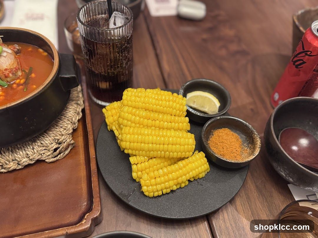 Corn on the cob with dipping spices and a drink
