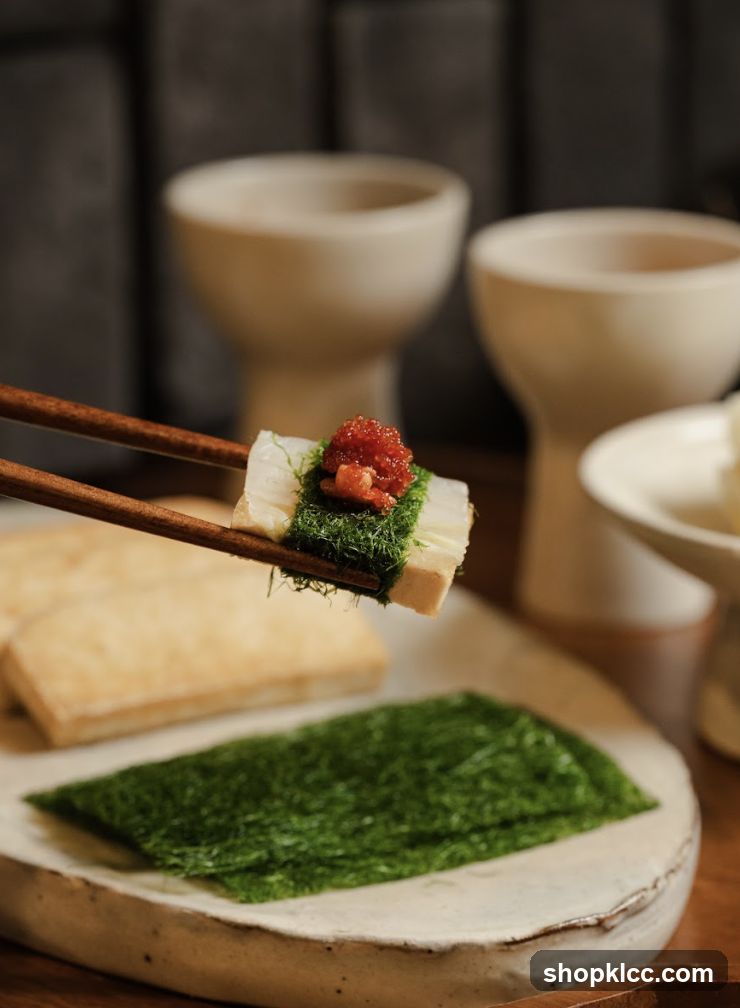 Close-up of a sushi roll being held by chopsticks