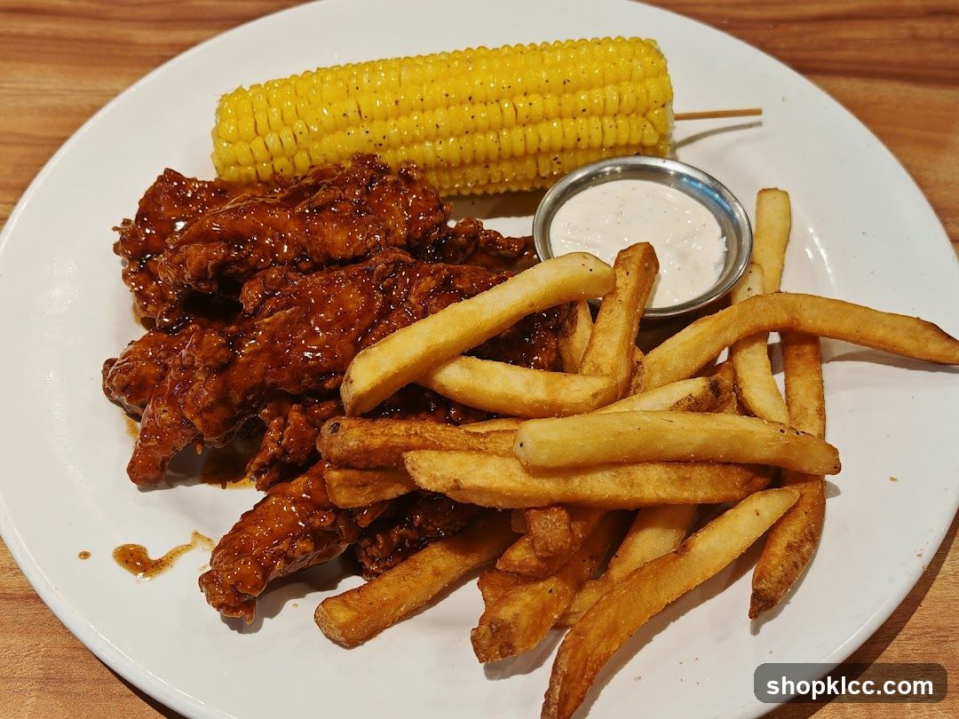 Chicken tenders with fries and corn on the cob