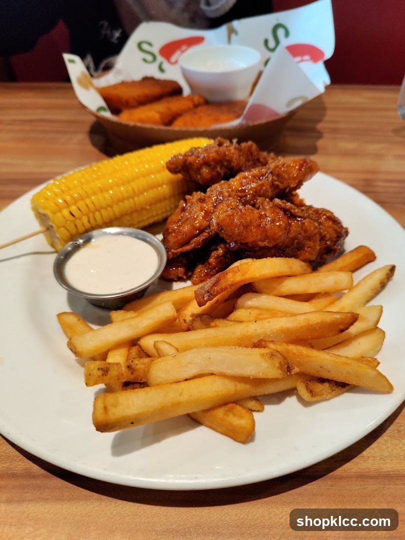 Chicken tenders with fries and corn on the cob