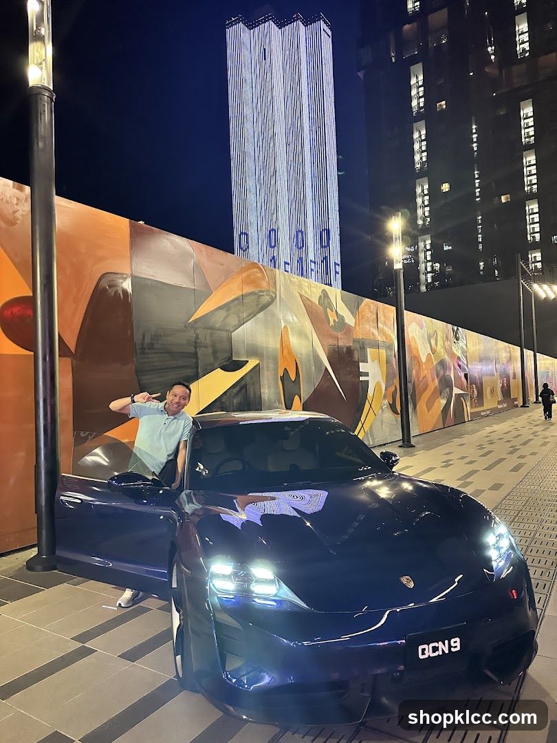 Man Posing with a Blue Sports Car at Night