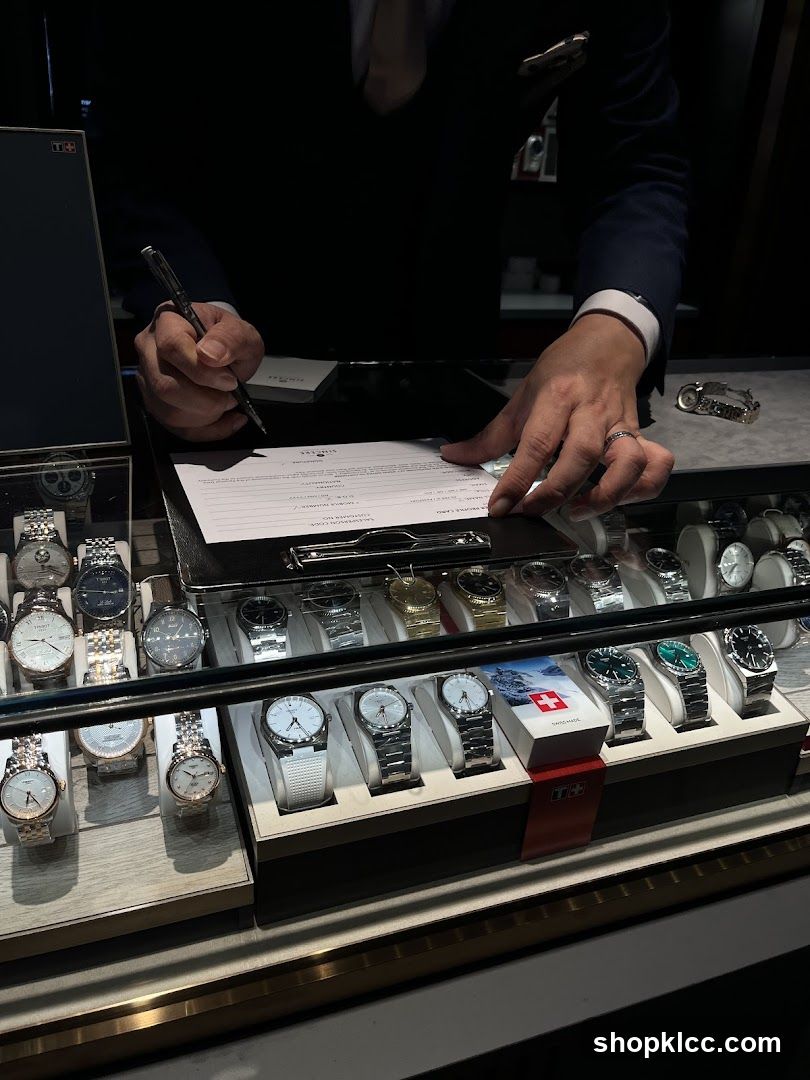 Salesperson filling out paperwork at a watch counter