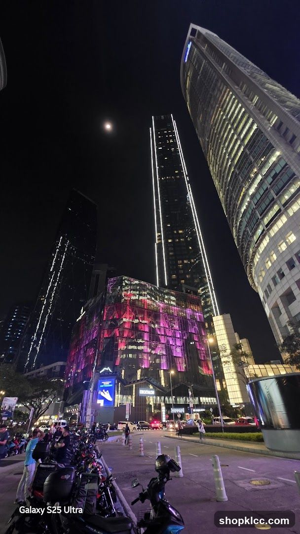 Cityscape at Night with Illuminated Buildings and Motorcycles