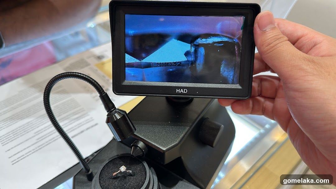 Hand holding monitor over jewelry inspection device