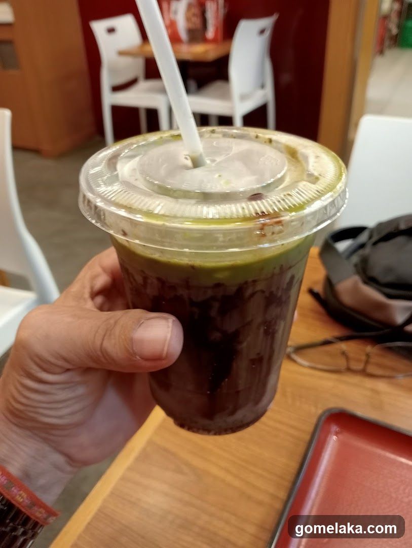 Hand holding iced beverage in café