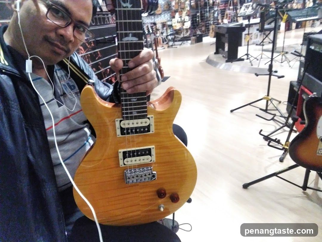 Man holding a guitar in a music store