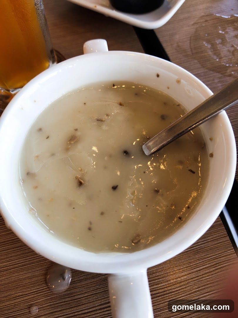 Soup in white mug with spoon