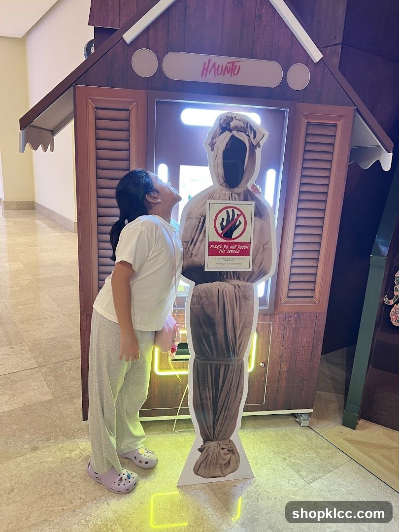 Girl posing with haunted figure cutout
