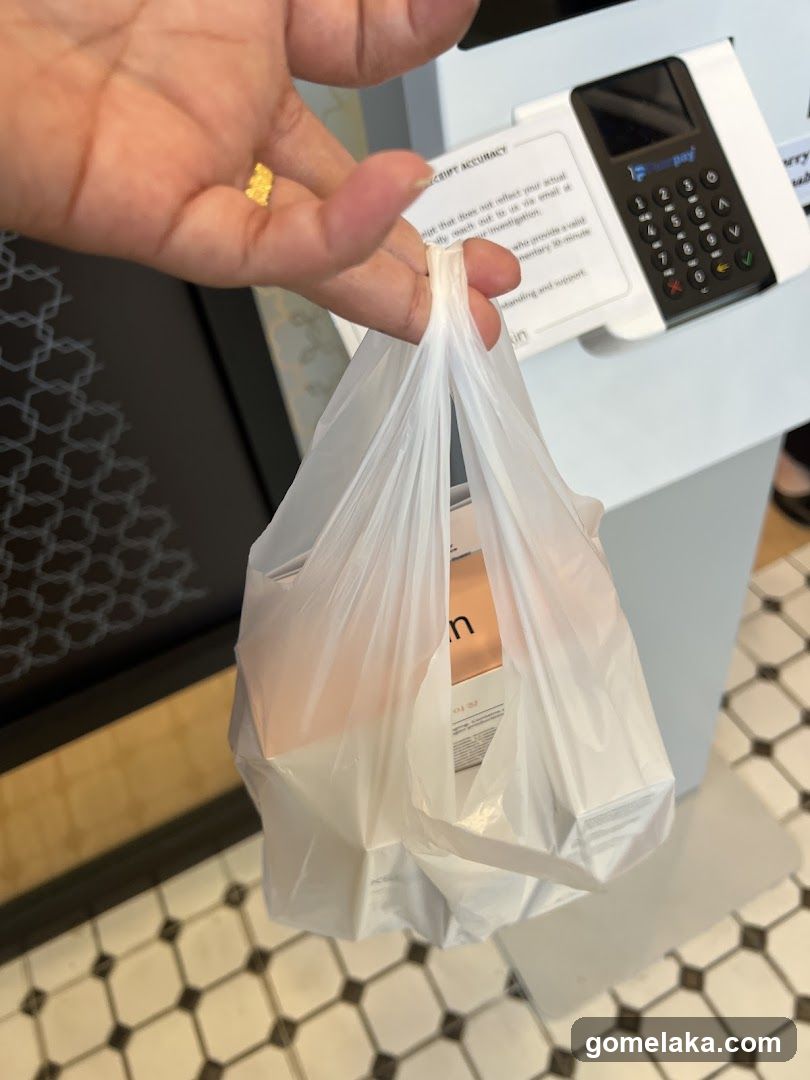 Hand holding shopping bag at checkout