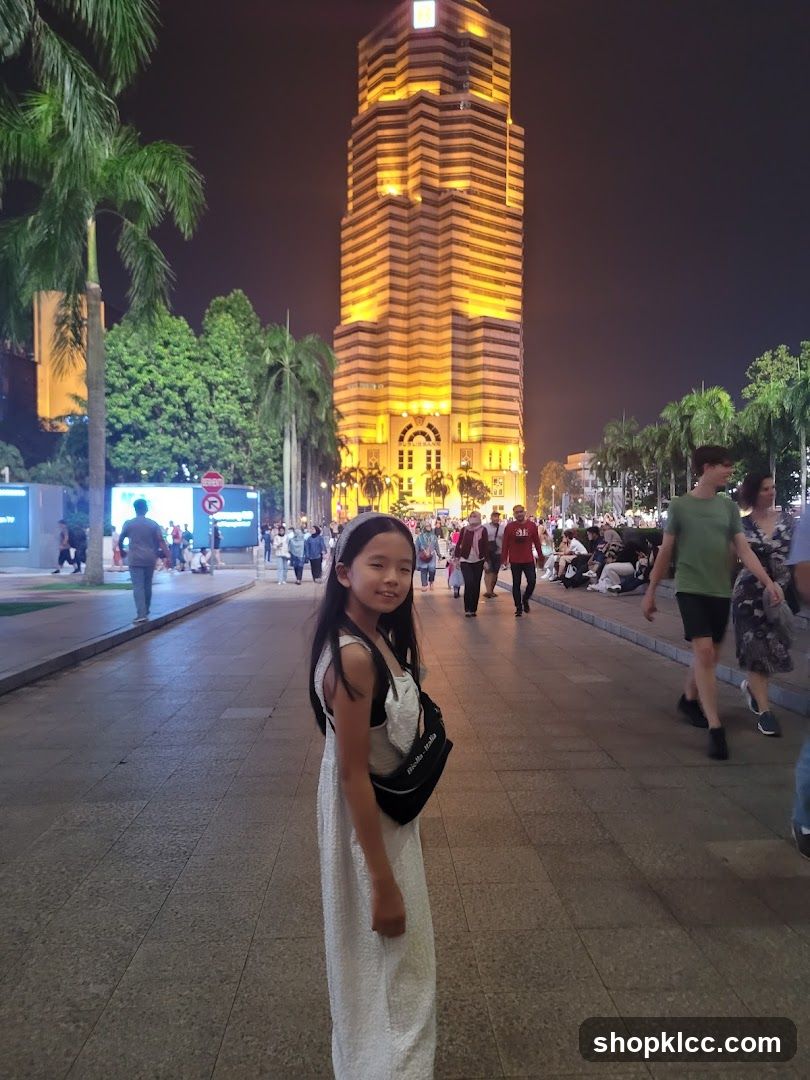 Girl in front of illuminated skyscraper