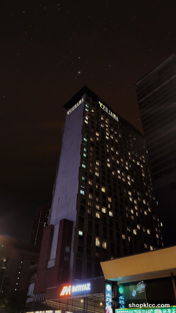Nighttime view of a tall building with illuminated windows and signage