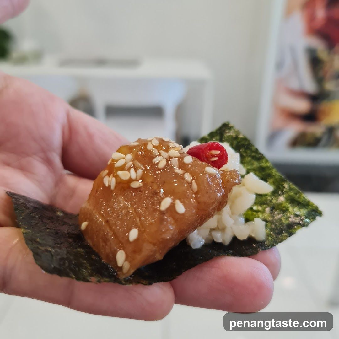 Hand holding a piece of sushi